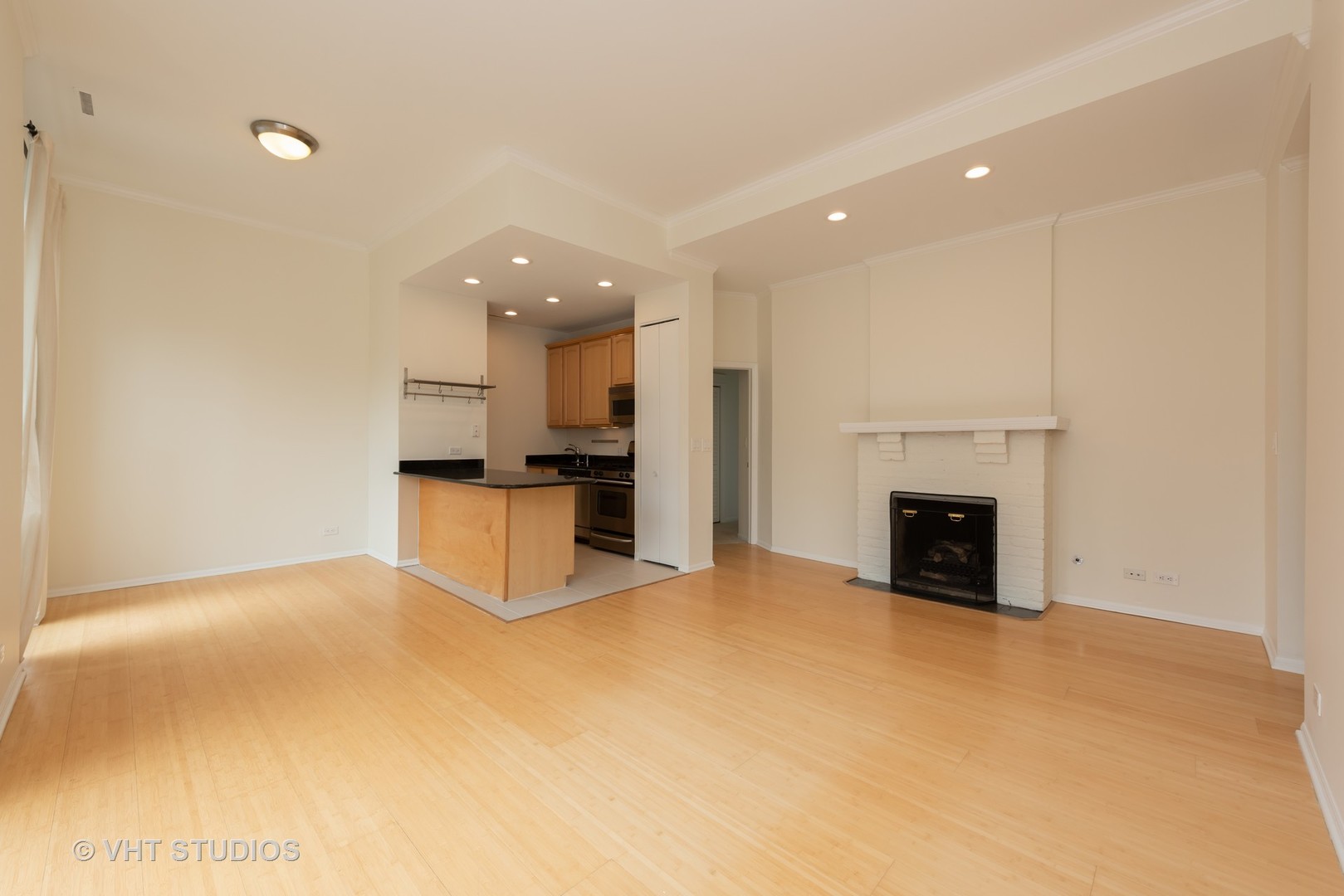 104 West Oak Street, Unit 2W Chicago, IL 60610 - Photo 6 of 17 a view of empty room with kitchen and fireplace