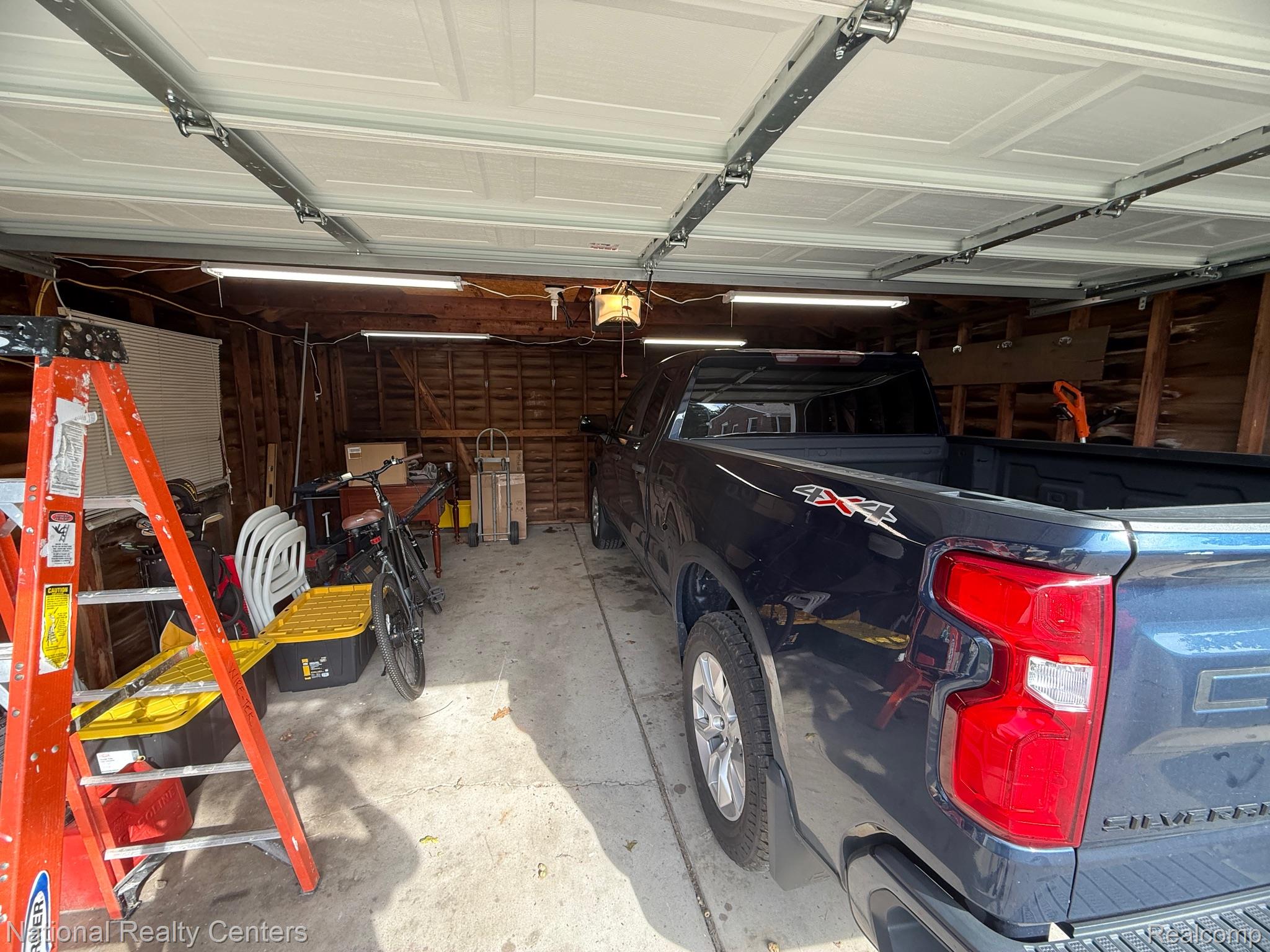 9918 Farmington Road Livonia, MI 48150 - Photo 14 of 14 Two-car garage with concrete flooring and exposed wood framing