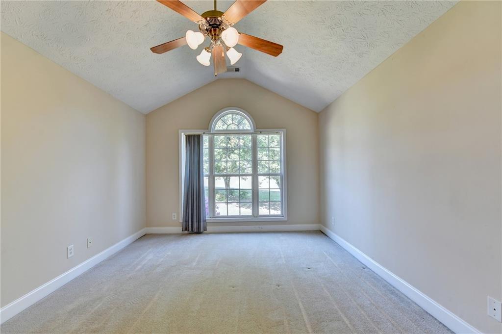 52 Katie Spring Lane Jefferson, GA 30549 - Photo 17 of 57 an empty room with a chandelier fan and windows