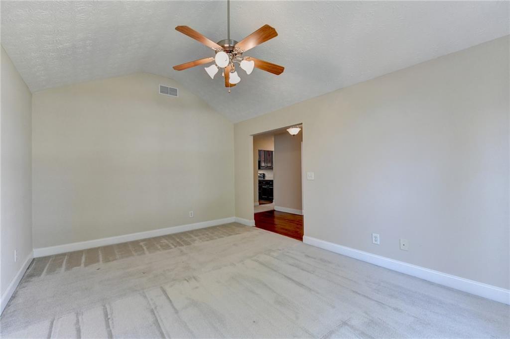 52 Katie Spring Lane Jefferson, GA 30549 - Photo 18 of 57 an empty room with a chandelier fan and wooden floor
