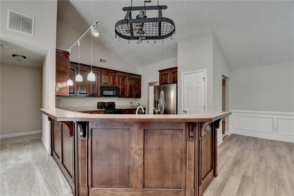 52 Katie Spring Lane Jefferson, GA 30549 - Photo 24 of 57 a kitchen with stainless steel appliances a table chairs in it and wooden floors