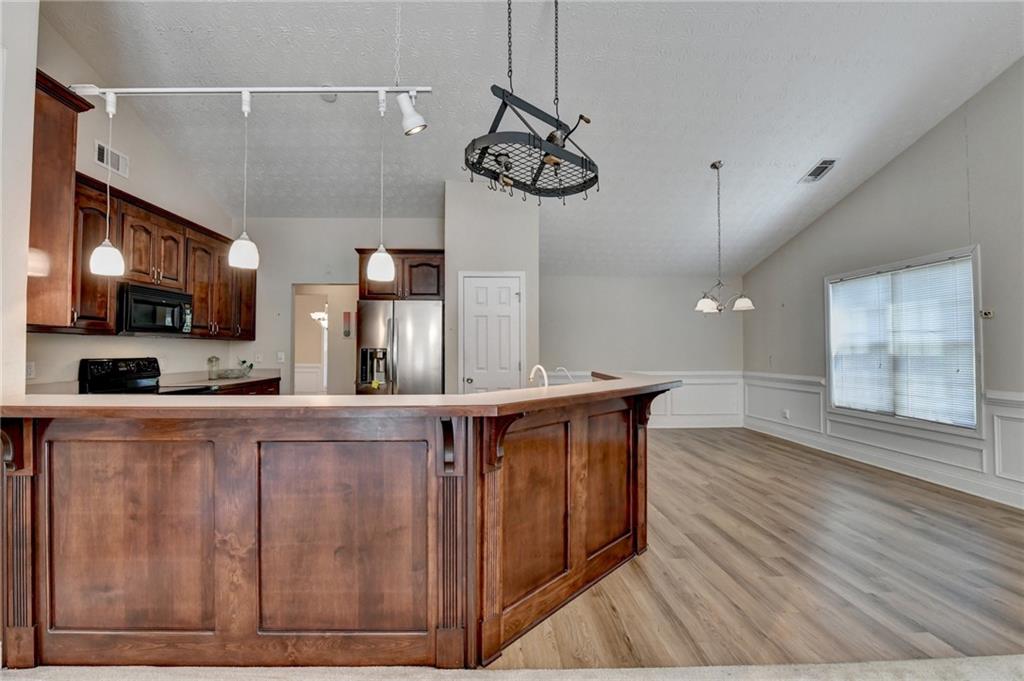 52 Katie Spring Lane Jefferson, GA 30549 - Photo 25 of 57 a large kitchen with stainless steel appliances a large counter space a sink and cabinets