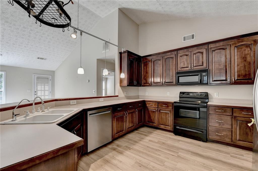 52 Katie Spring Lane Jefferson, GA 30549 - Photo 26 of 57 a kitchen with stainless steel appliances granite countertop a sink and wooden cabinets