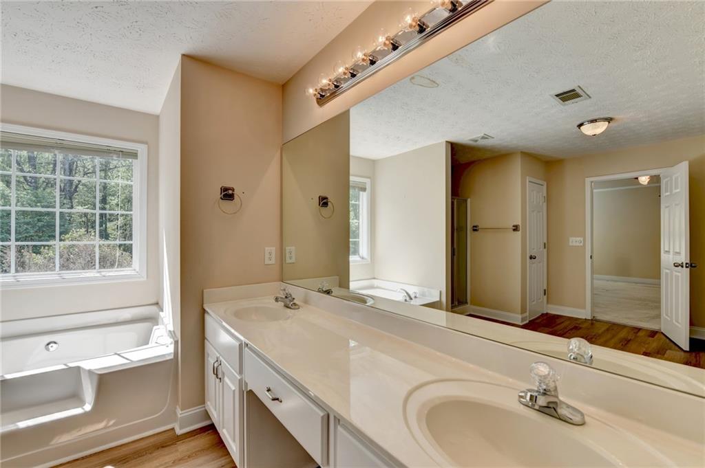 52 Katie Spring Lane Jefferson, GA 30549 - Photo 39 of 57 a bathroom with a tub sink and mirror