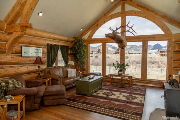 a living room with furniture fireplace and a large window
