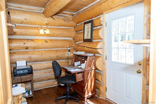 a view of a workspace with furniture and a window