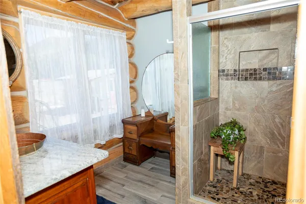 a bathroom with a granite countertop shower a sink and a mirror