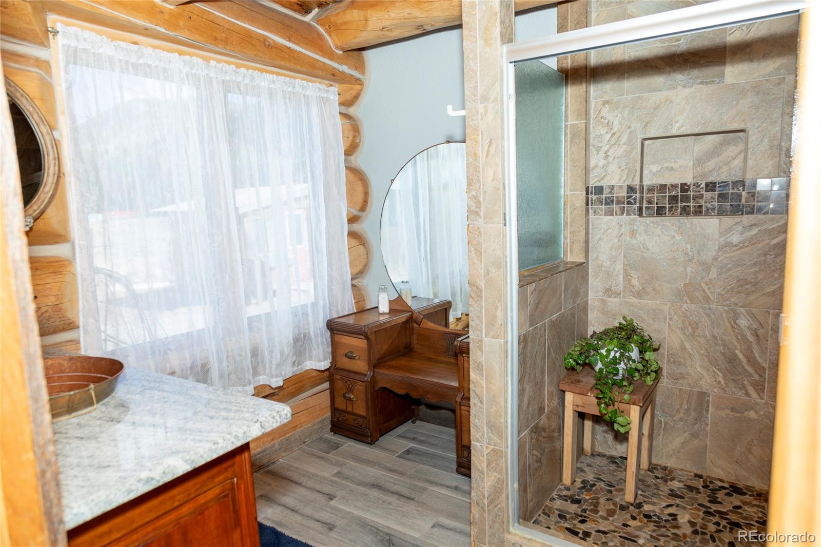 108 Forest Road, Unit 552 Creede, CO 81130 - Photo 23 of 32 a bathroom with a granite countertop shower a sink and a mirror