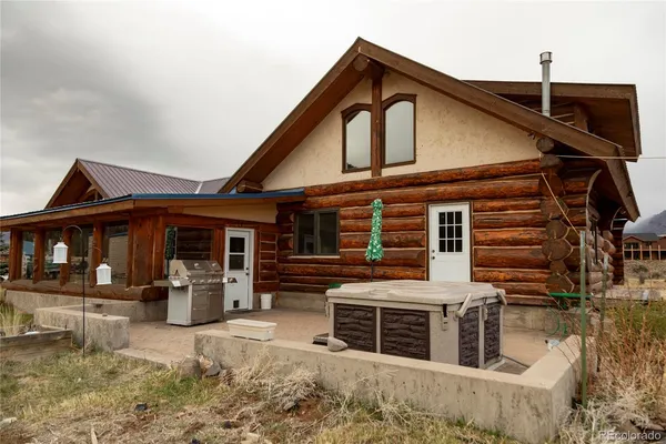 a front view of a house with barbeque and wooden fence