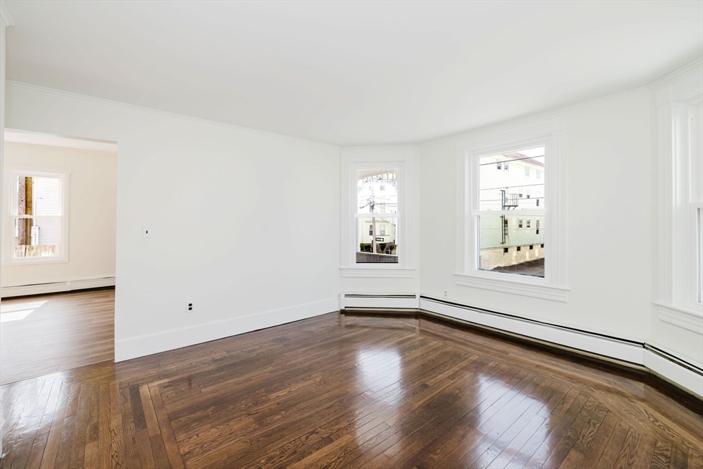 194 Albion Street Fall River, MA 02723 - Photo 22 of 42 an empty room with wooden floor and windows