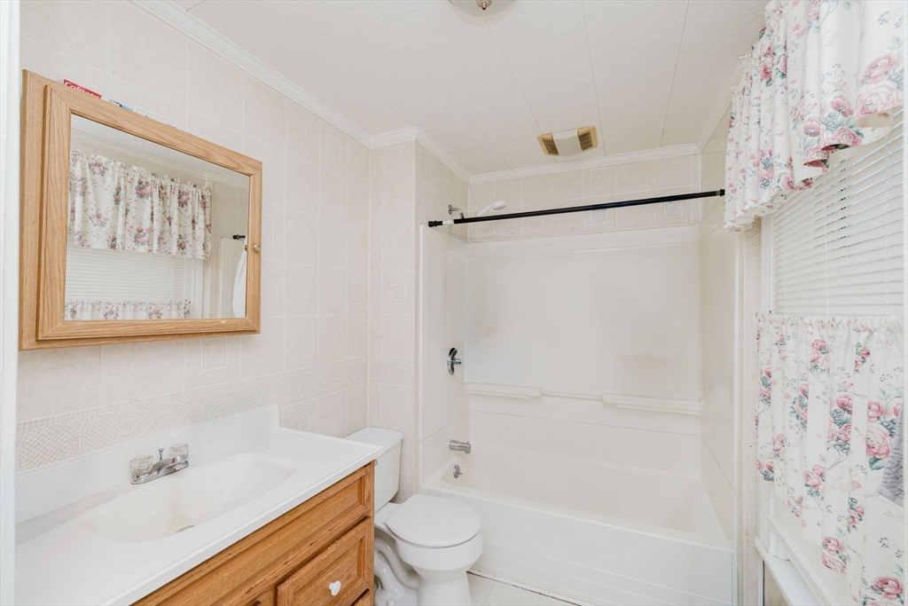194 Albion Street Fall River, MA 02723 - Photo 39 of 42 a bathroom with a shower curtain a sink and a toilet