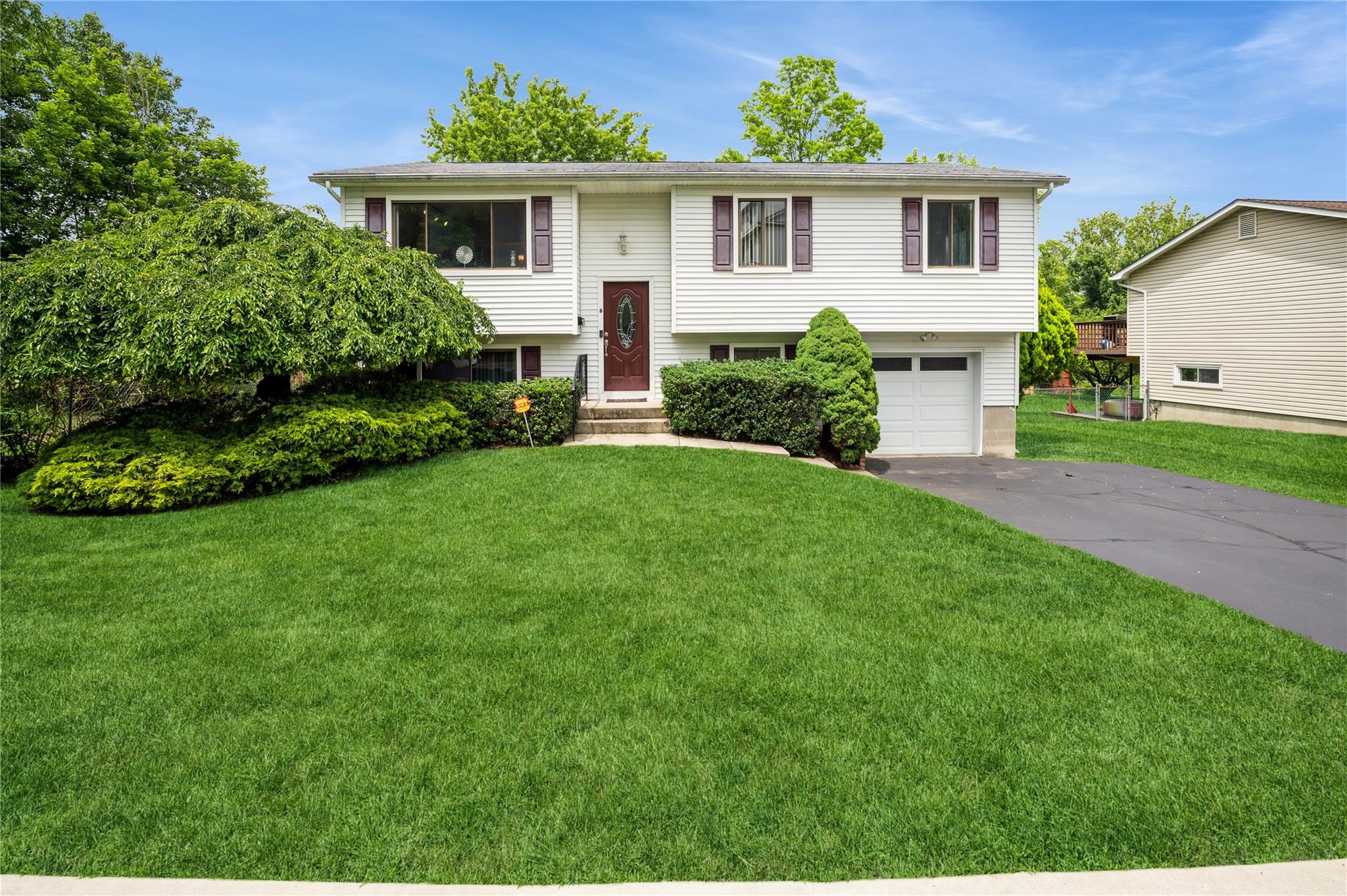 a front view of a house with a garden and plants