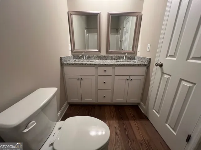 a bathroom with a toilet a sink and mirror