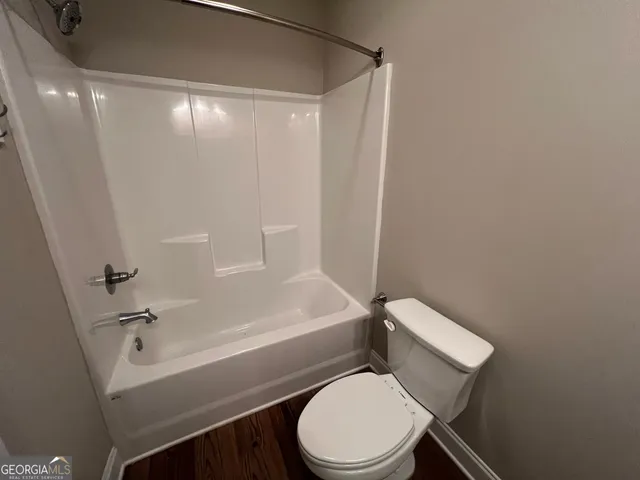 a white toilet sitting next to a bath tub
