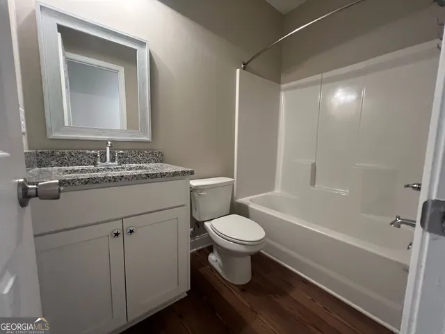 a bathroom with a sink toilet a mirror and shower