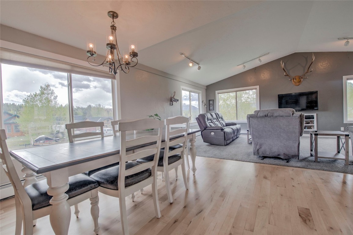 231 Alpine Road Dillon, CO 80435 - Photo 6 of 40 a view of a dining room with furniture a chandelier and wooden floor