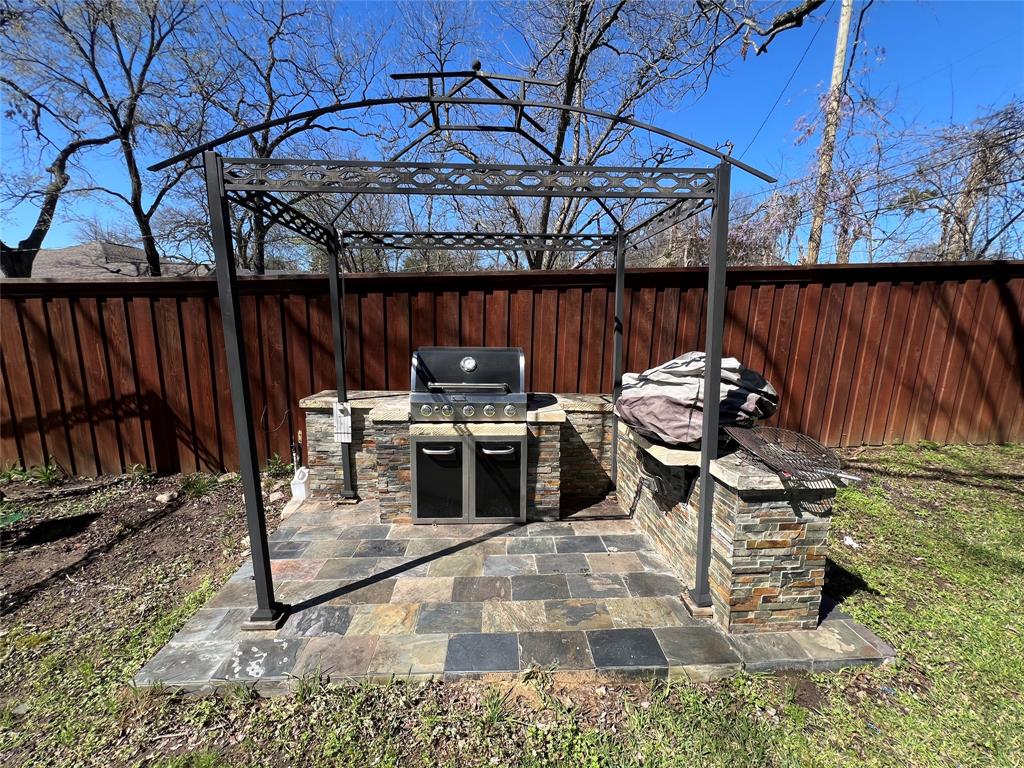 533 East Sears Street Denison, TX 75021 - Photo 25 of 27 a view of a patio with table and chairs with wooden fence