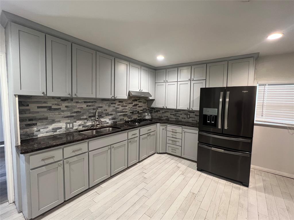 533 East Sears Street Denison, TX 75021 - Photo 7 of 27 a kitchen with granite countertop a refrigerator sink and microwave