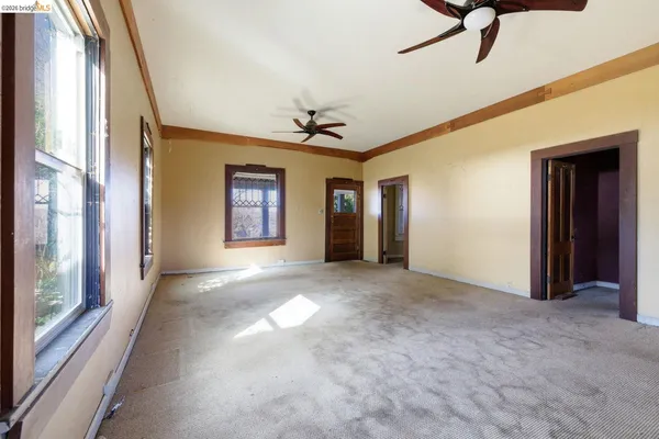 a view of a big room with windows and chandelier fan