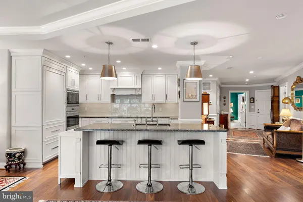 a kitchen with cabinets and chairs