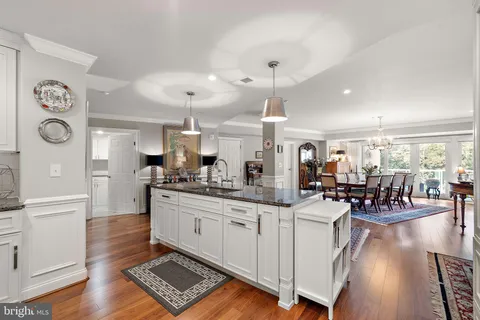 a large white kitchen with lots of counter space and stainless steel appliances