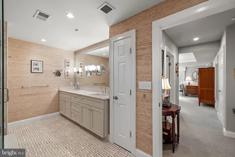 a bathroom with a glass door shower a sink and a mirror