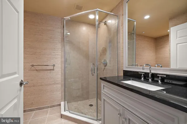 a bathroom with a shower sink and mirror