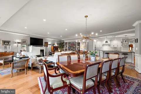a dining room with furniture a rug and a kitchen view