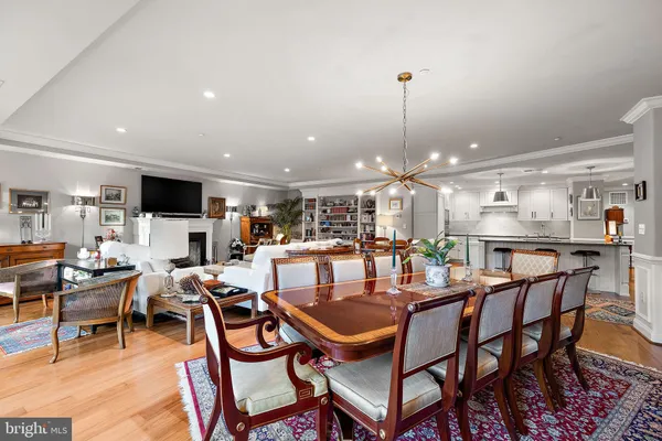 a dining room with furniture a rug and a kitchen view