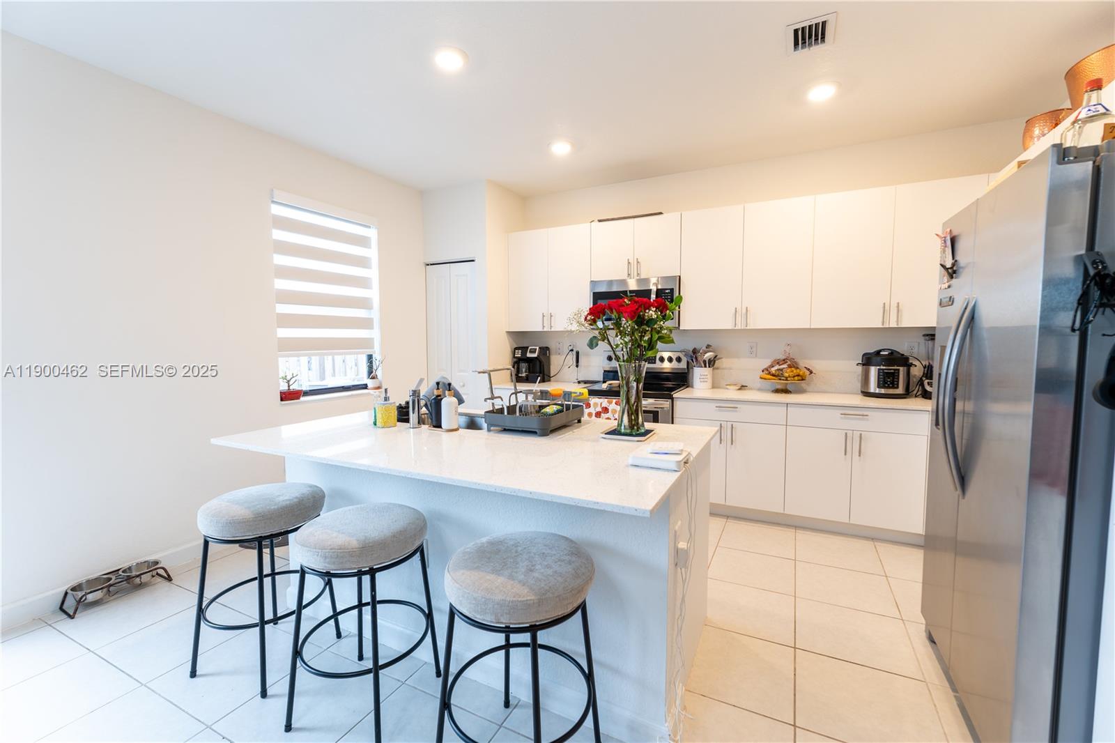 13132 Southwest 234th Terrace Homestead, FL 33032 - Photo 10 of 24 a kitchen with granite countertop a refrigerator and a stove top oven