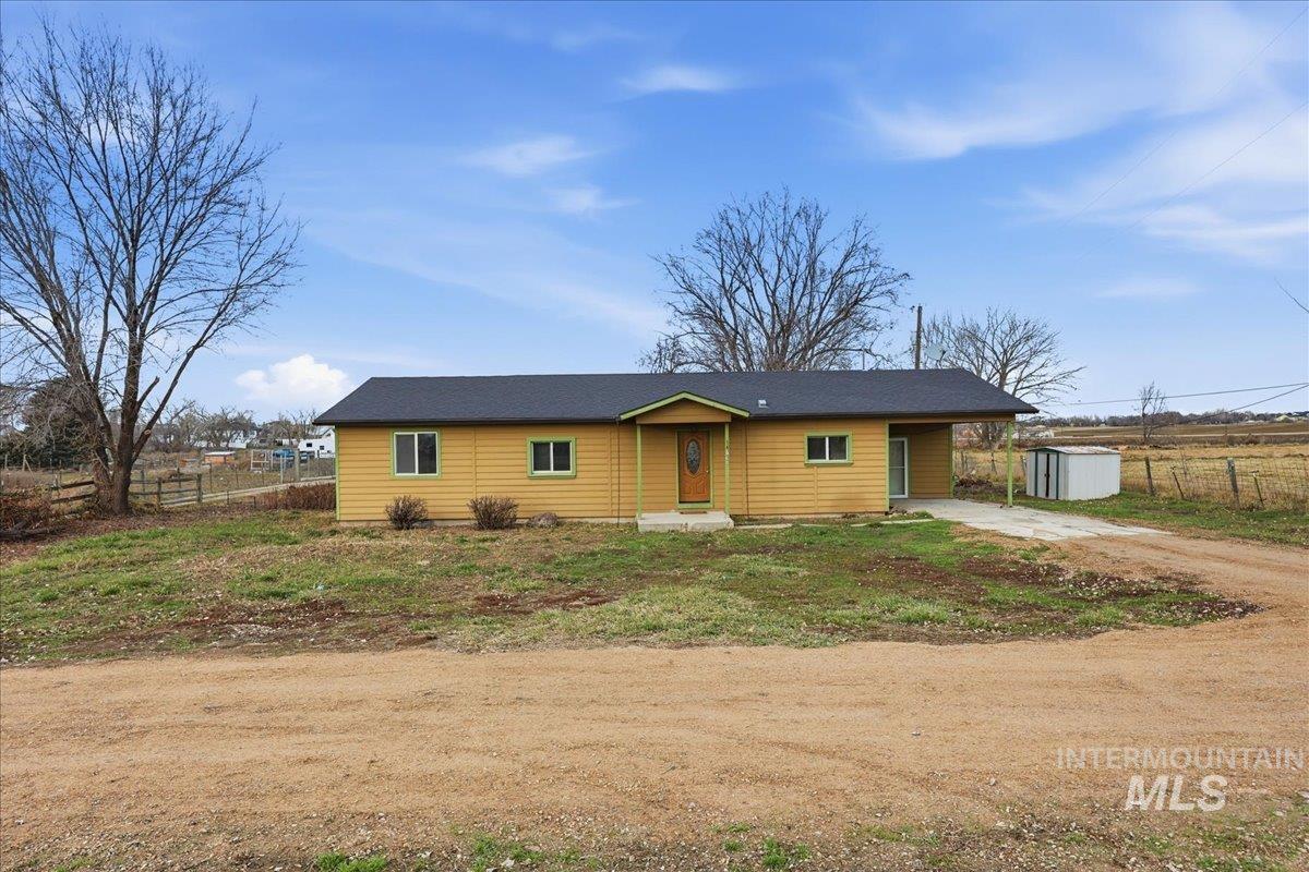 View of front of property with driveway and a carport