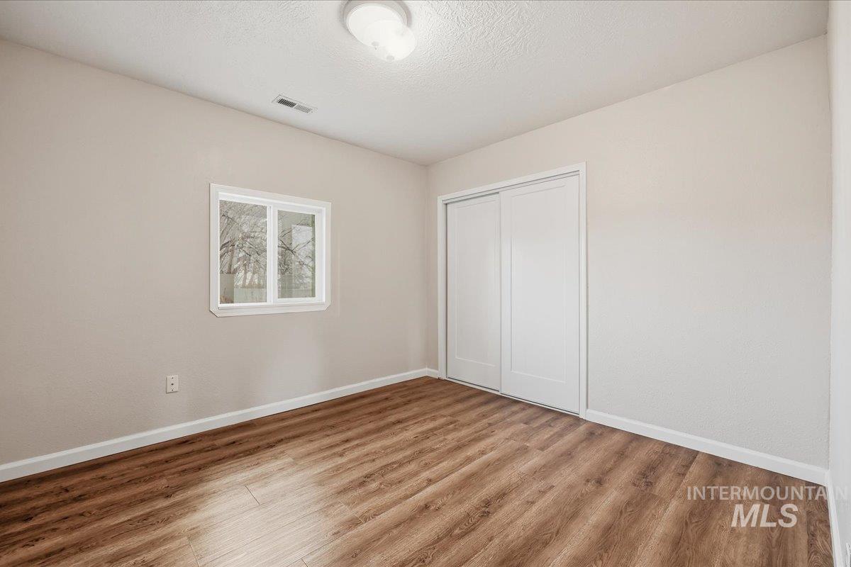14666 Willis Road Caldwell, ID 83607 - Photo 15 of 23 Unfurnished bedroom (11 x 10) with wood finished floors, a closet, and a textured ceiling