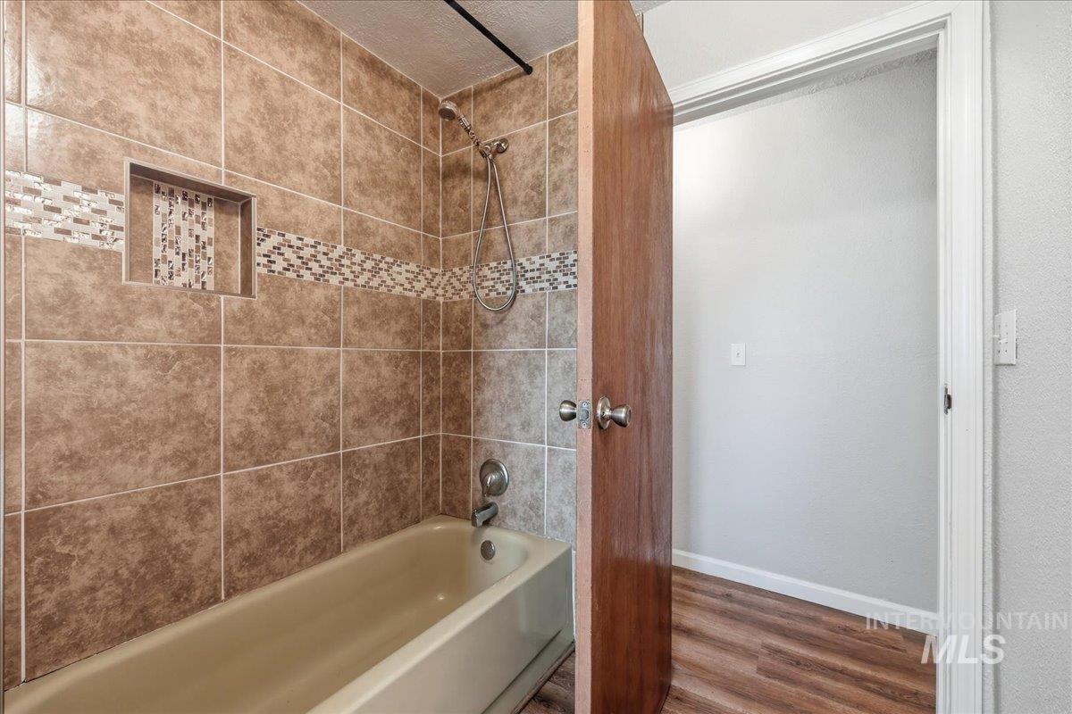 14666 Willis Road Caldwell, ID 83607 - Photo 17 of 23 Full bathroom featuring wood finished floors and tub / shower combination
