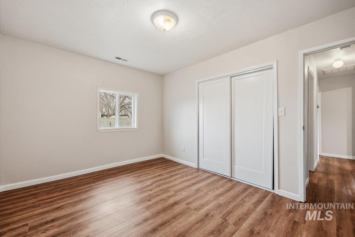 14666 Willis Road Caldwell, ID 83607 - Photo 18 of 23 Unfurnished bedroom 10 x 13 featuring a textured ceiling, wood finished floors, and a closet