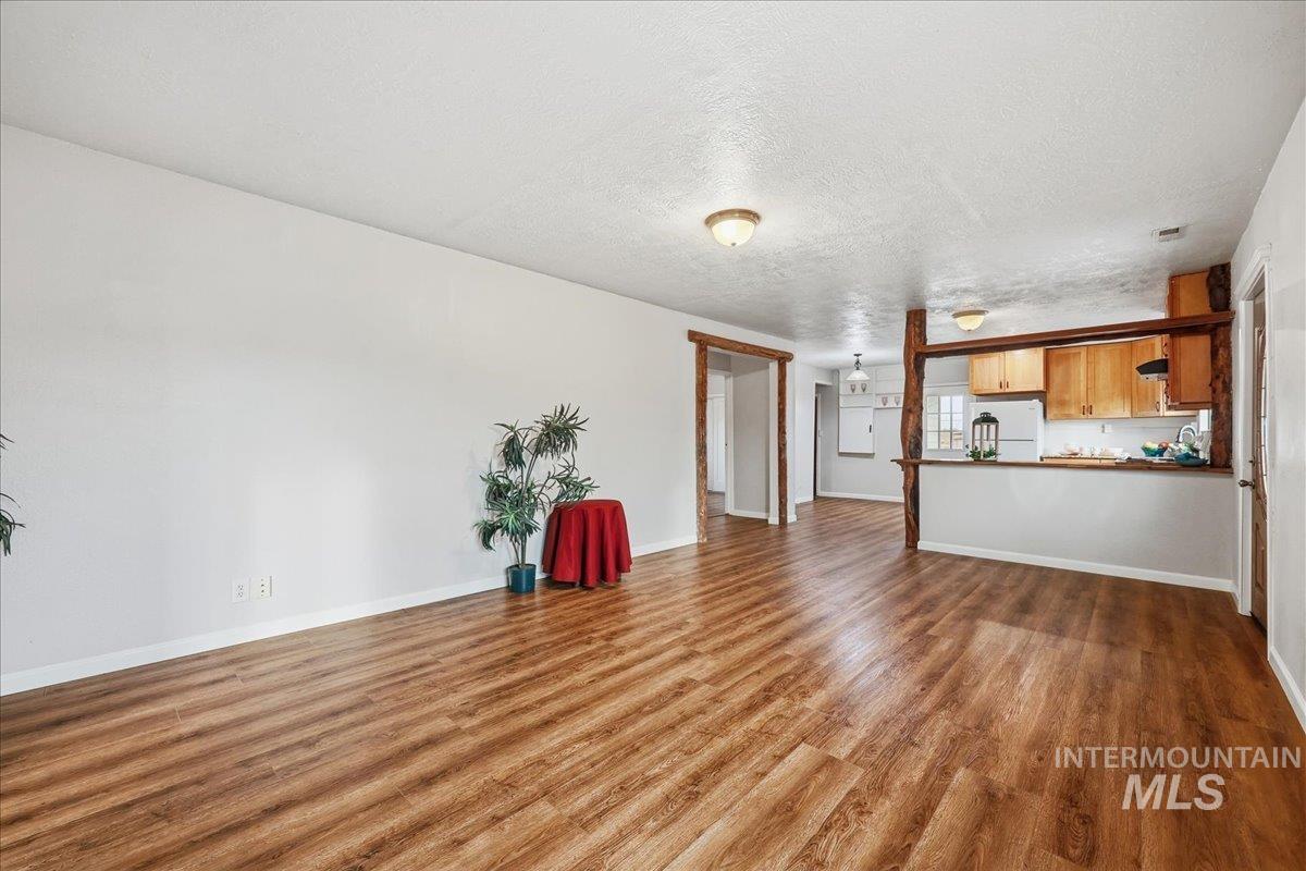14666 Willis Road Caldwell, ID 83607 - Photo 8 of 23 Unfurnished living room with a textured ceiling and dark wood finished floors