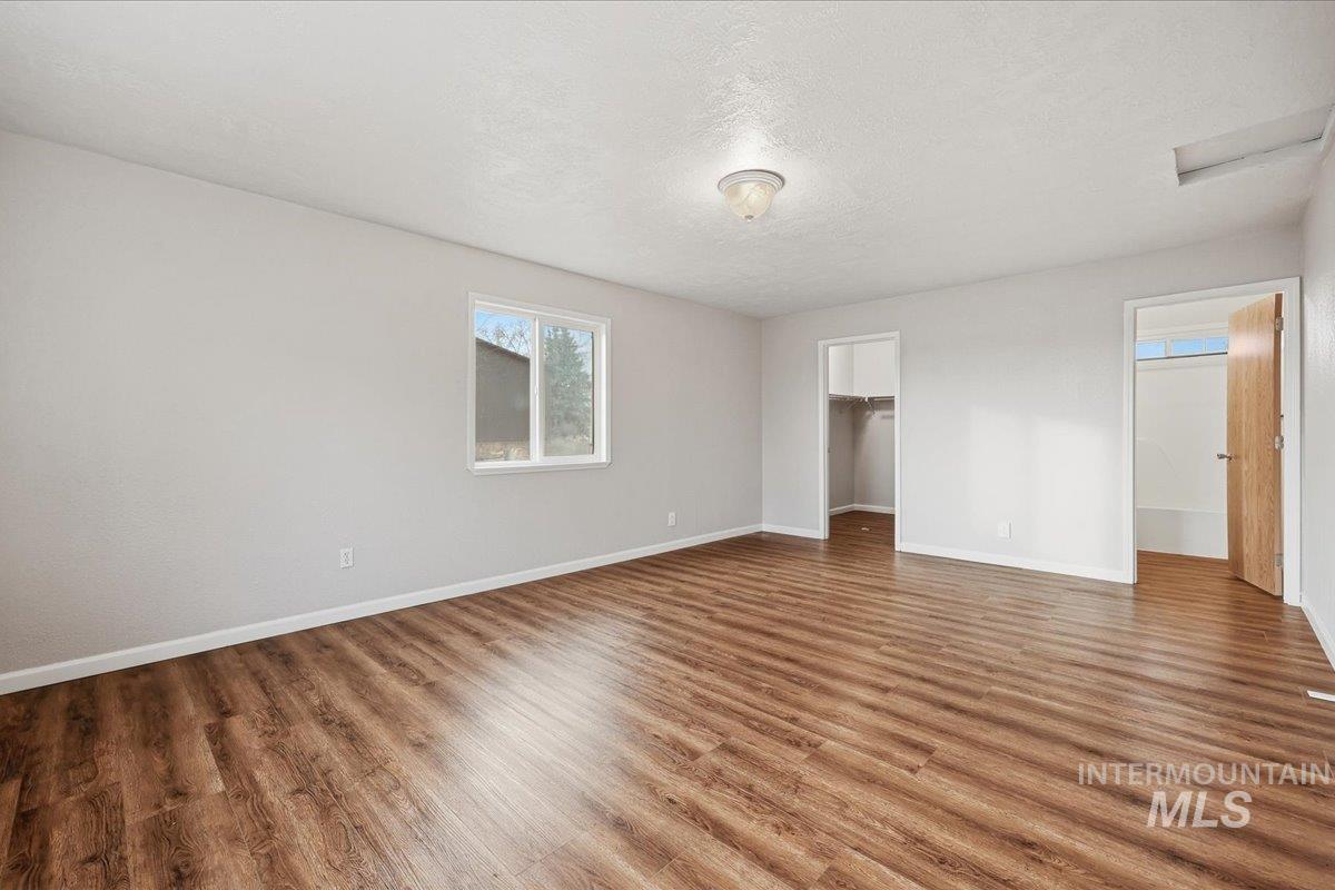 14666 Willis Road Caldwell, ID 83607 - Photo 10 of 23 Unfurnished bedroom with a spacious closet, a textured ceiling, and wood finished floors