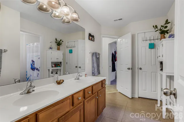 a spacious bathroom with a double vanity sink mirror and shower