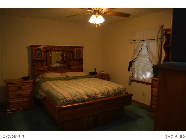15713 Saddlebrook Road Chesterfield, VA 23838 - Photo 12 of 19 a bed sitting in a bedroom next to a lamp