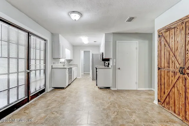 a view of kitchen with stainless steel appliances refrigerator oven and cabinets