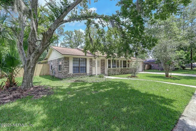 a view of a house with a yard and sitting area