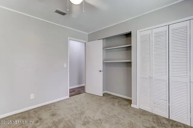 a view of an empty room with a ceiling fan