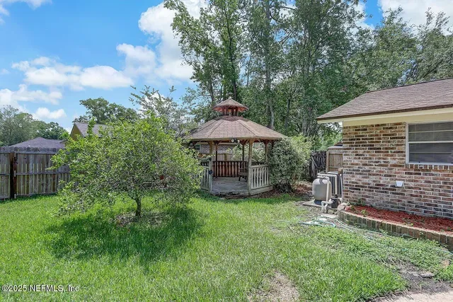 a backyard of a house with table and chairs