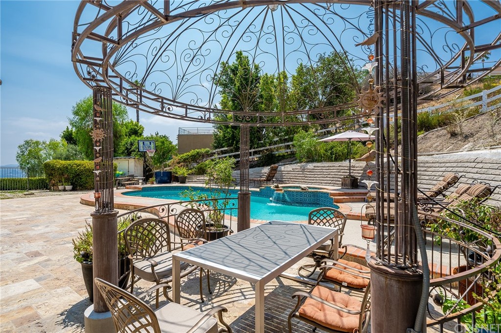 163 Dapplegray Road Bell Canyon, CA 91307 - Photo 6 of 7 a view of a patio with table and chairs under an umbrella with potted plants