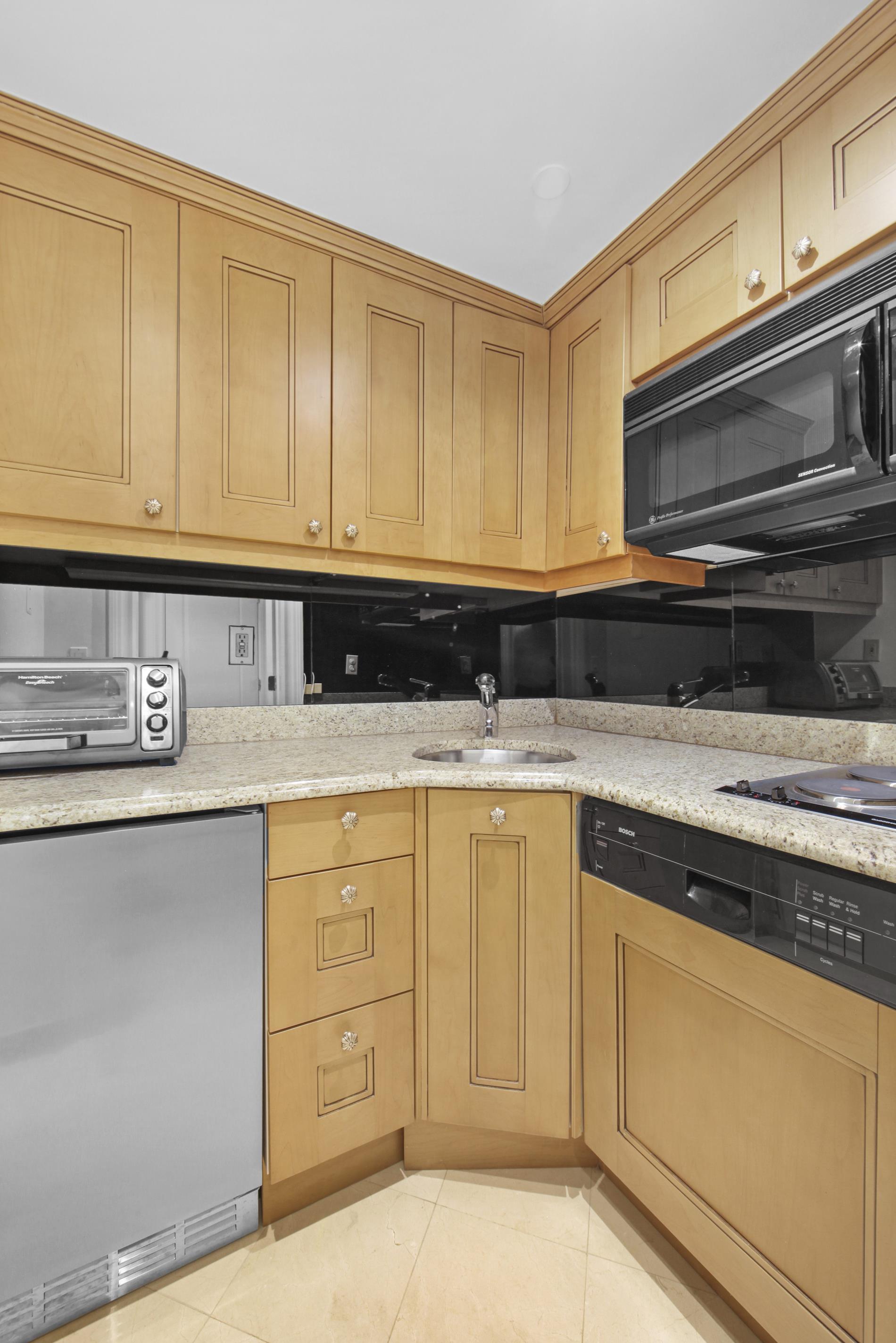 160 Central Park South, Unit 2118/2120 Manhattan, NY 10019 - Photo 10 of 16 a kitchen with granite countertop cabinets stainless steel appliances and a sink