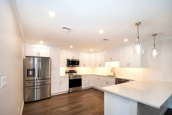 a kitchen with refrigerator a sink and wooden floor