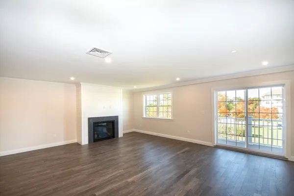 an empty room with wooden floor and fireplace