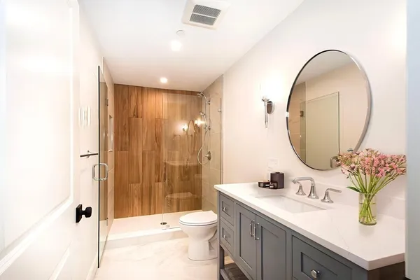a bathroom with a sink a toilet and a mirror