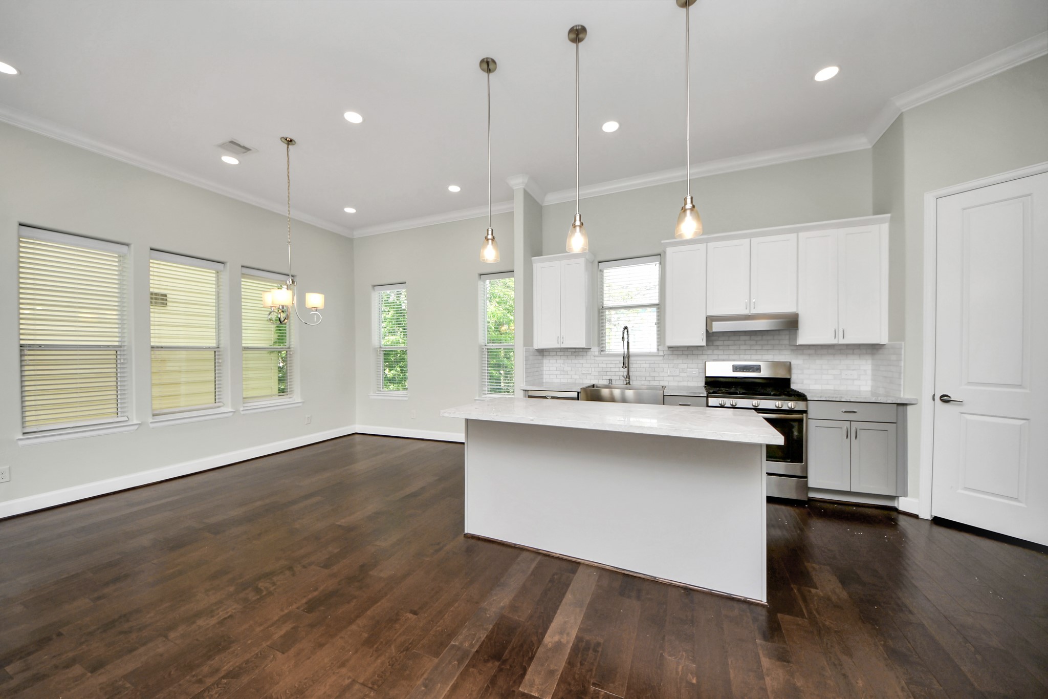 1716 Stuart Street Houston, TX 77004 - Photo 17 of 39 a open kitchen with kitchen island a sink wooden floor and a stove
