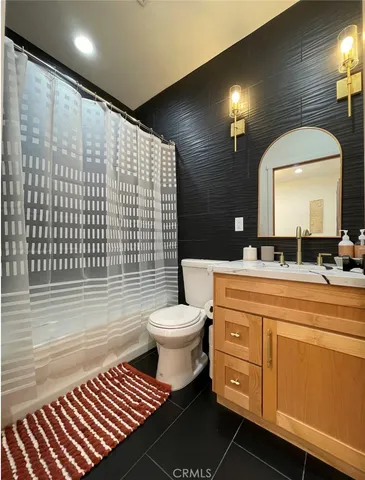 a bathroom with a toilet a sink and mirror