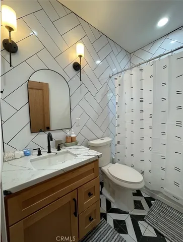 a bathroom with a granite countertop toilet sink and mirror